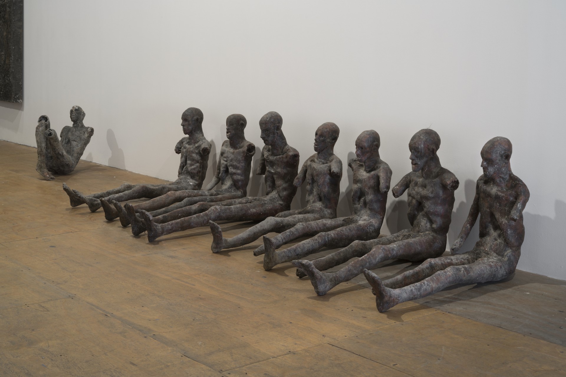 Luther Price, *Ground Piece Two, (Seven Sitting Figures, One Broken Figure)*, 1984. Metal, plastic, dirt