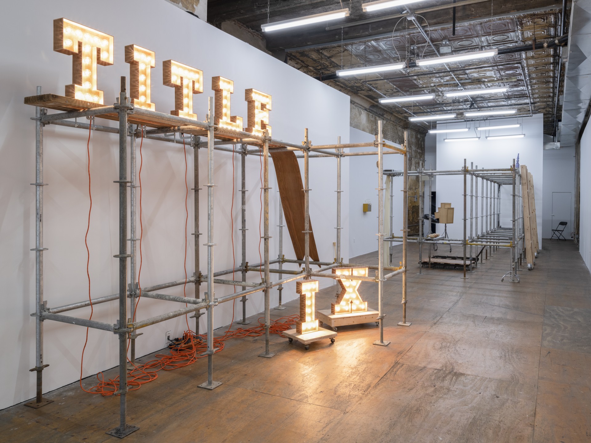 Anna Campbell, *Title IX* (detail), 2022, mahogany veneer, plywood, lightbulbs, clamps, electrical cords, dollies, installation view at Participant Inc. Photo: Daniel Kukla.