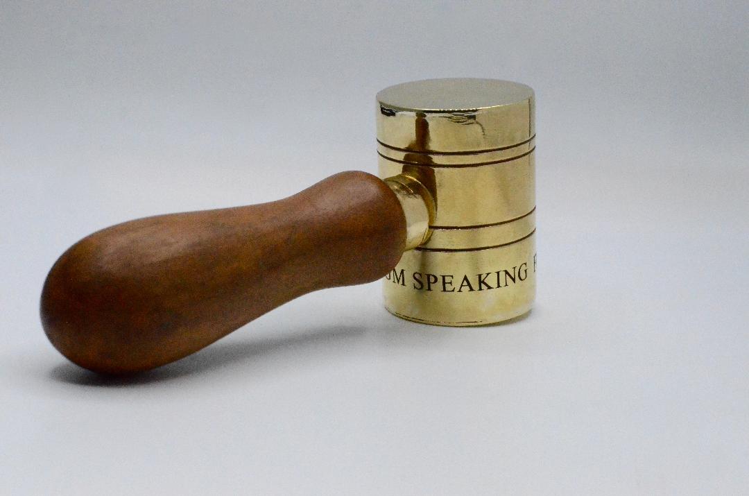 Jelena Behrend, Vaginal Davis Presidential Gavel, 2020. Photo courtesy Jelena Behrend Studio. [A gold gavel with a dark brown wood handle, onto which four horizontal bands are engraved, as well as the word 