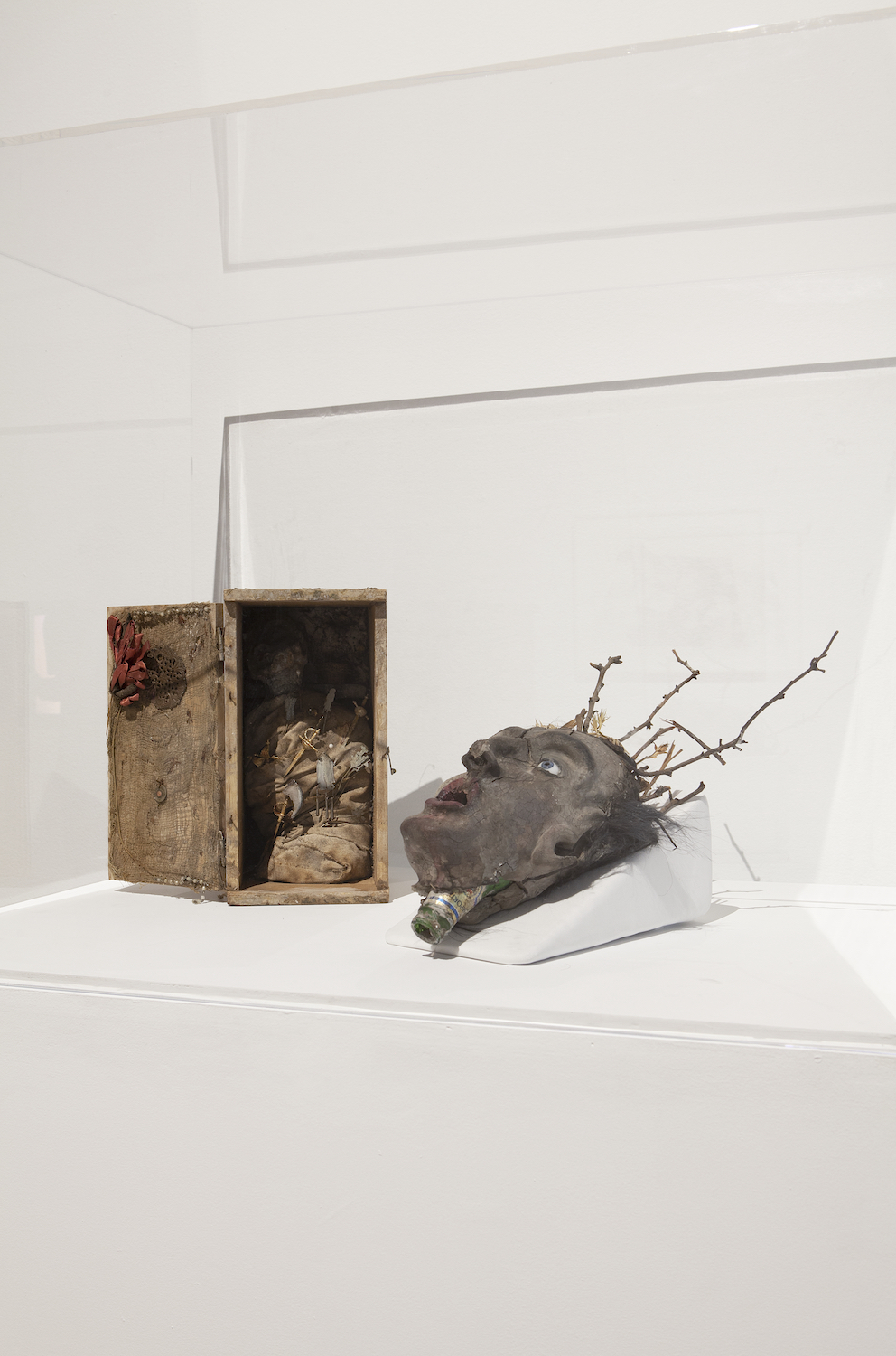 Cookie Mueller, *Title unknown*, c. 1984. Clay, wooden branches, dried flowers, paint, and prosthetic eyes; *Title unknown*, c. 1984. Clay, wooden box, amulets, hat pins, metal knives, ribbon, and fabric