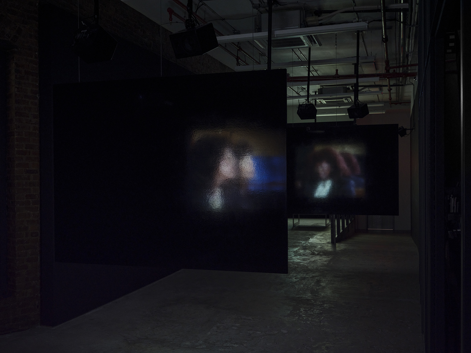 Elisabeth Subrin, *The Listening Takes / Manal Issa, 2024*, 2024, installation view; pictured *The Listening Takes*, 2023-2024, <br>30:00 minutes, 3-channel 16mm/HD video, 9-channel sound, speakers, suspended screens, Photo: Daniel Kukla